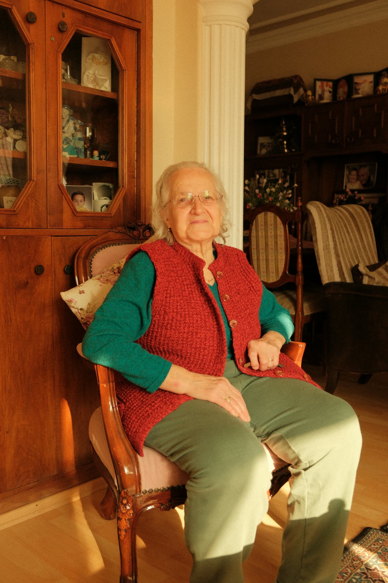 Seniorin sitzt entspannt in ihrem Wohnzimmer